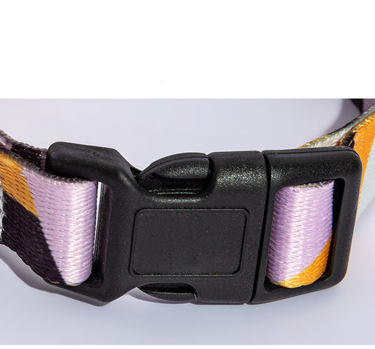 Close-up of plastic side-release buckle on purple and yellow geometric patterned dog collar