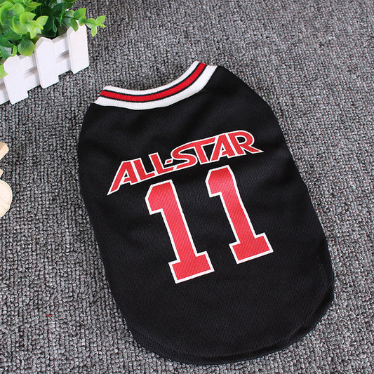 Black All-Star dog vest laid flat on grey surface near green plant