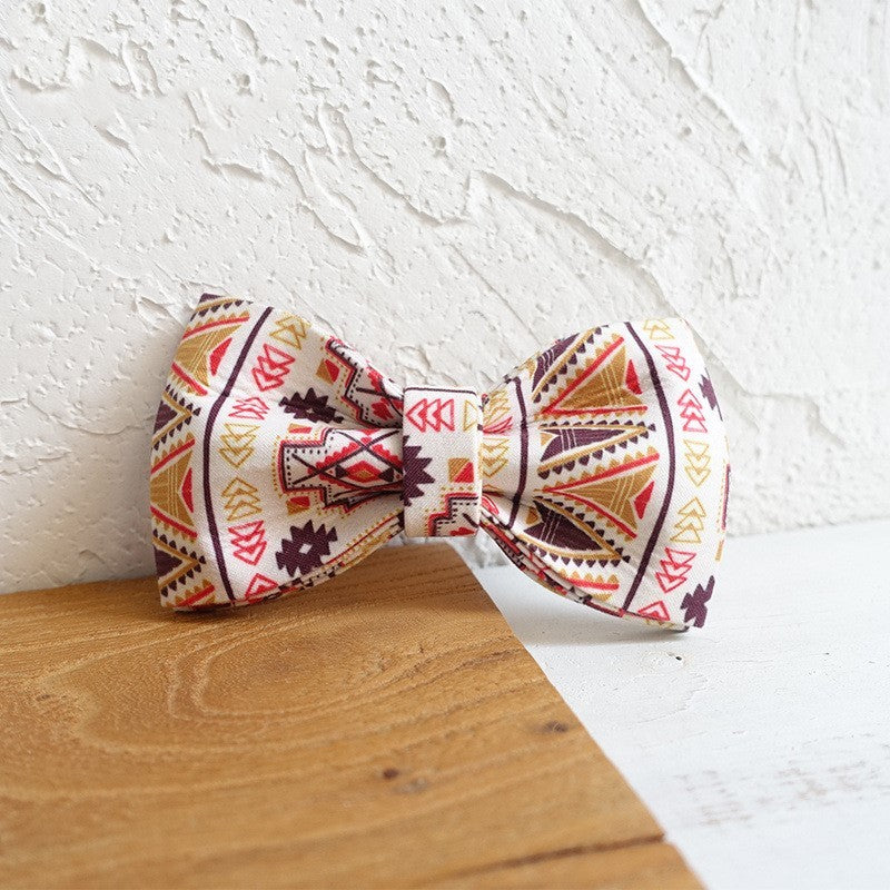Detachable bow tie with ethnic pattern placed against a wall