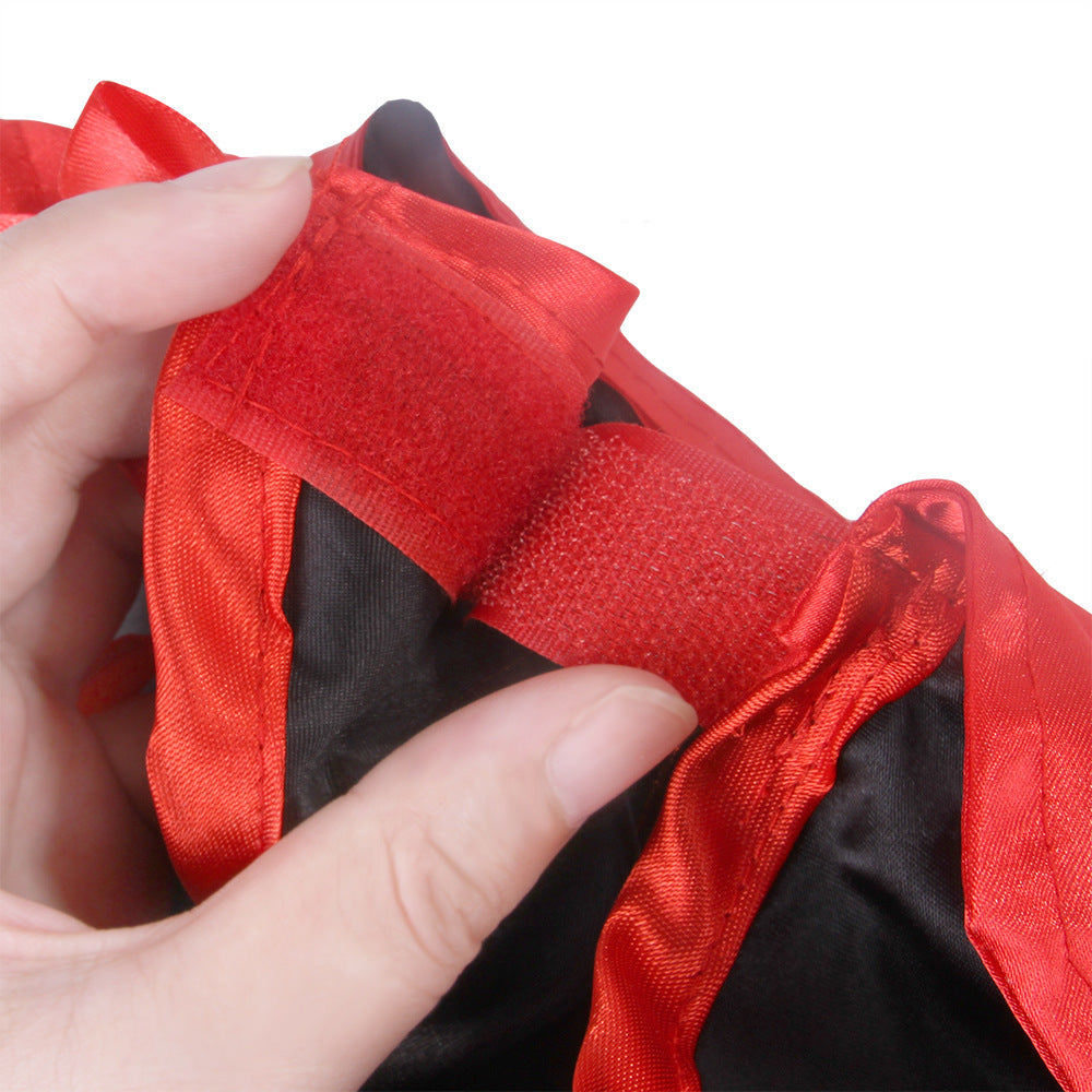 Close-up of red velcro fastener on black and red satin pet cape