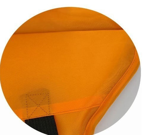 Close-up of orange water-resistant fabric and reinforced stitching of dog life jacket