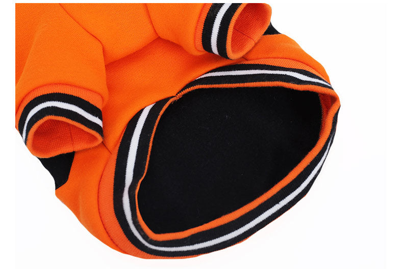 Close-up of the belly side of orange pumpkin dog sweater with black and white trim