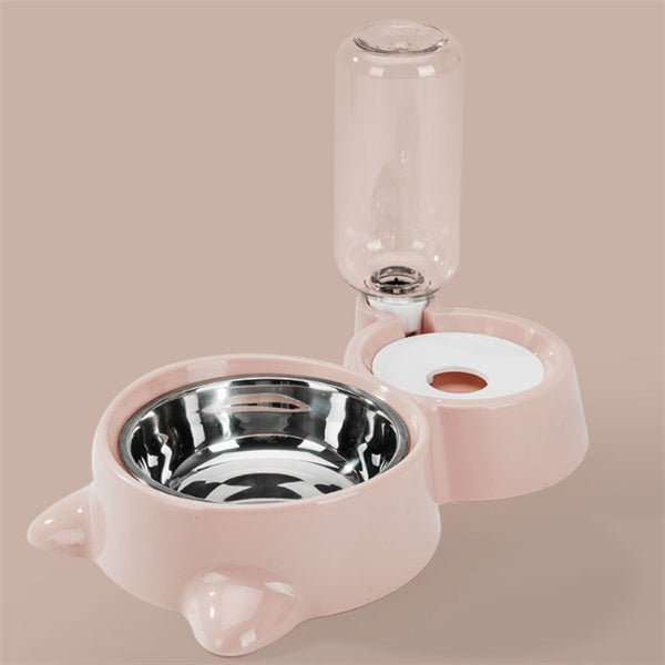 Green automatic pet feeding station with stainless steel bowl and clear water bottle on green background