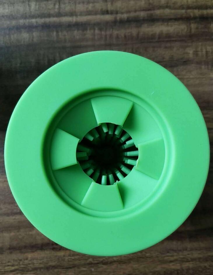 Top view of green silicone dog paw washer showing the flexible bristles opening