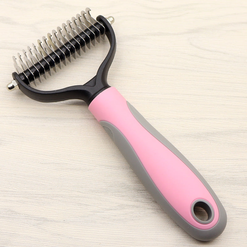 Pink and grey handled dog grooming comb resting on wooden surface