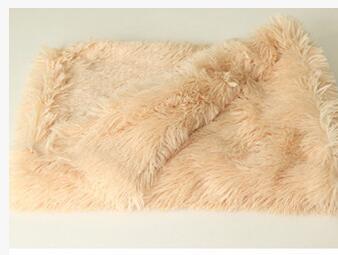Beige plush pet blanket folded, close-up showing fluffy texture