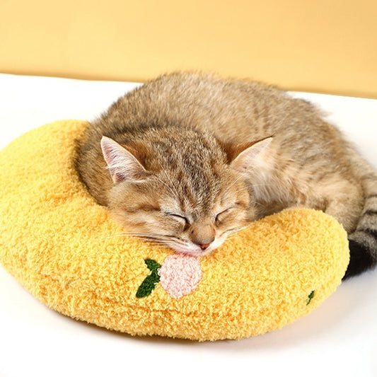 Cat resting on yellow crescent-shaped plush pet pillow with floral embroidery