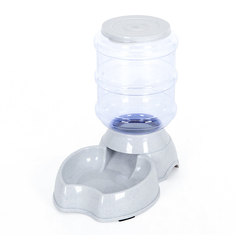 White pet feeding station with transparent water reservoir and gray feed bowl base