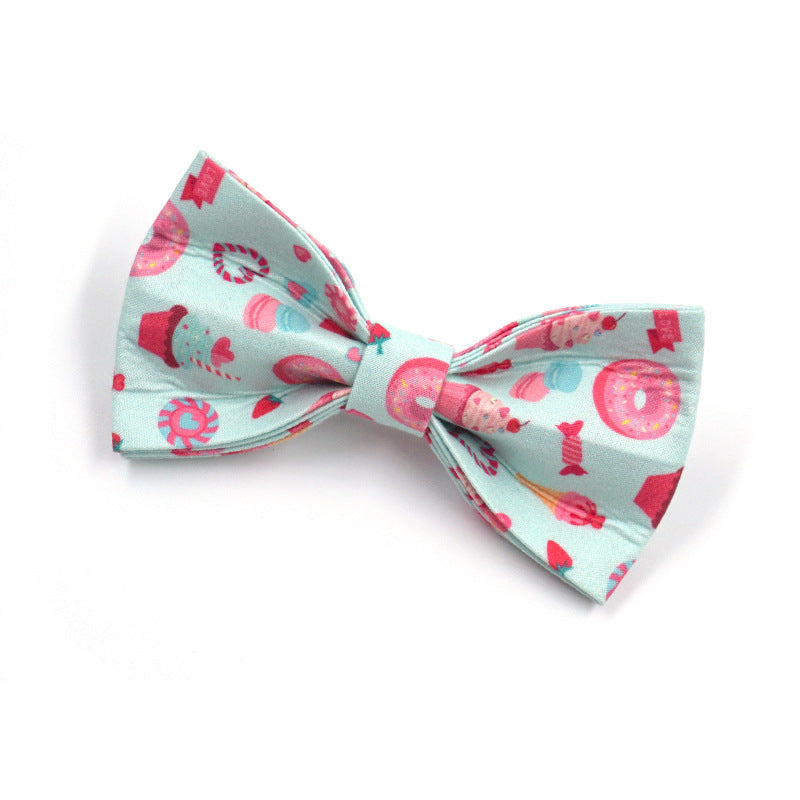 Pastel blue dog collar with attached decorative bow tie adorned with sweet treat cartoon prints