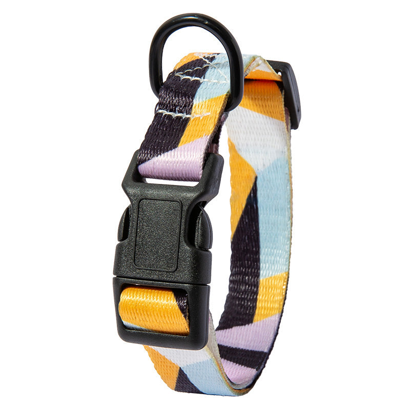 Close-up of plastic buckle and D-ring on purple, yellow, and black geometric patterned dog collar