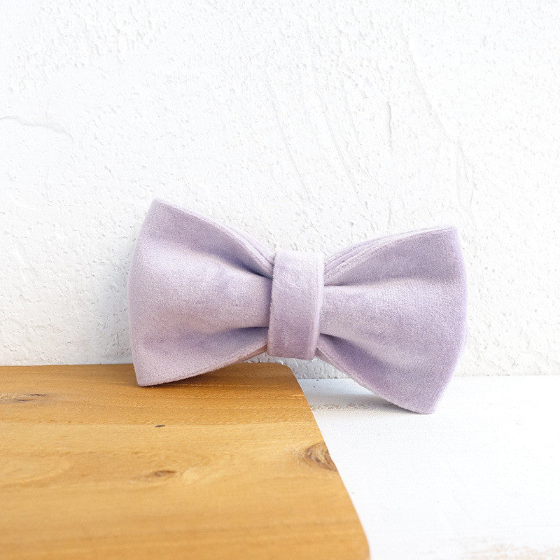 Detailed close-up of plush velvet bow tie sitting on wooden and white surface