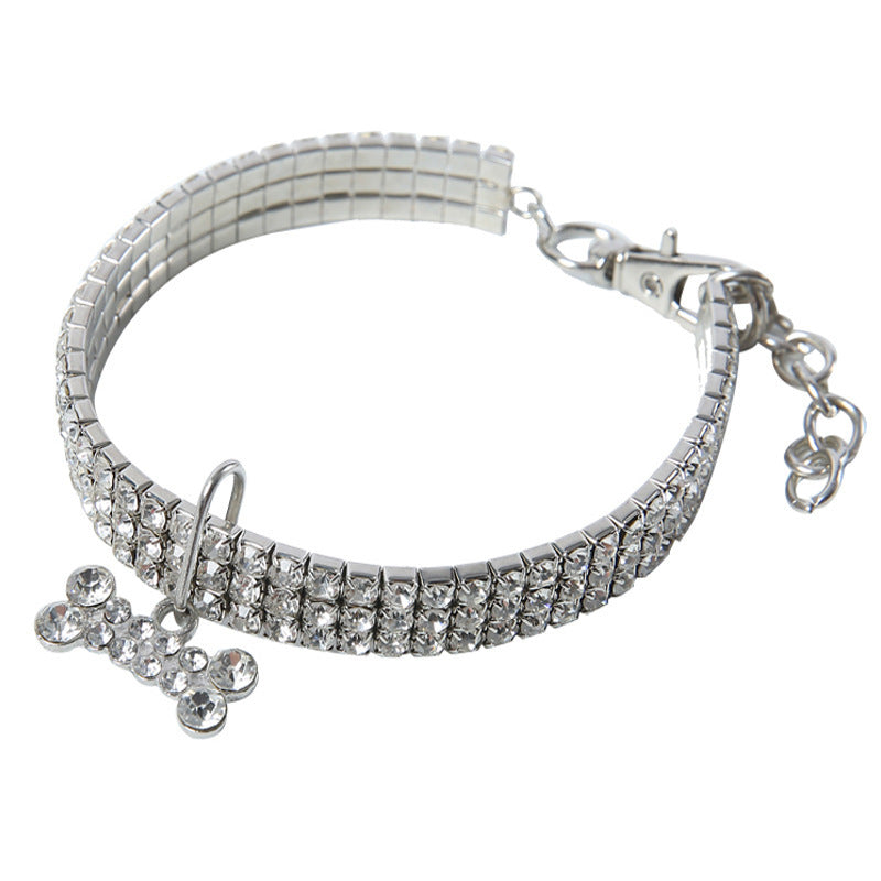 Clear rhinestone dog collar laid flat with bone-shaped crystal pendant and adjustable clasp
