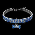 Charger l'image dans la visionneuse de la galerie, Blue rhinestone dog collar with crystal bone charm displayed on black background
