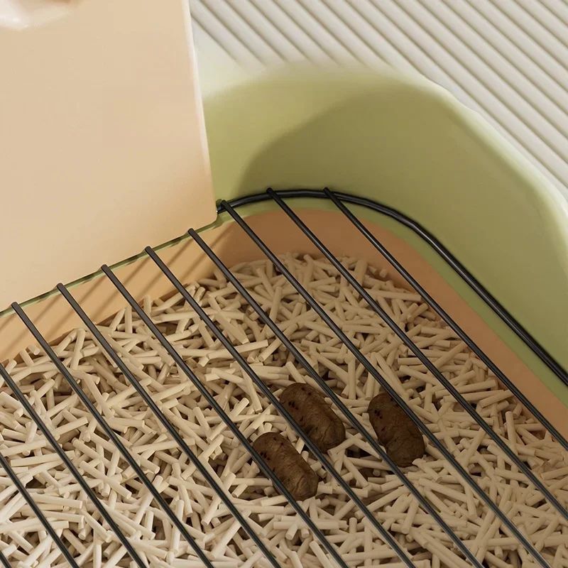 Close-up view of beige and peach dog potty tray showing plastic base, metal grate, and simulated waste on plastic tray