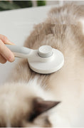 Load image into Gallery viewer, Gray handle comb used to groom a cat's back gently
