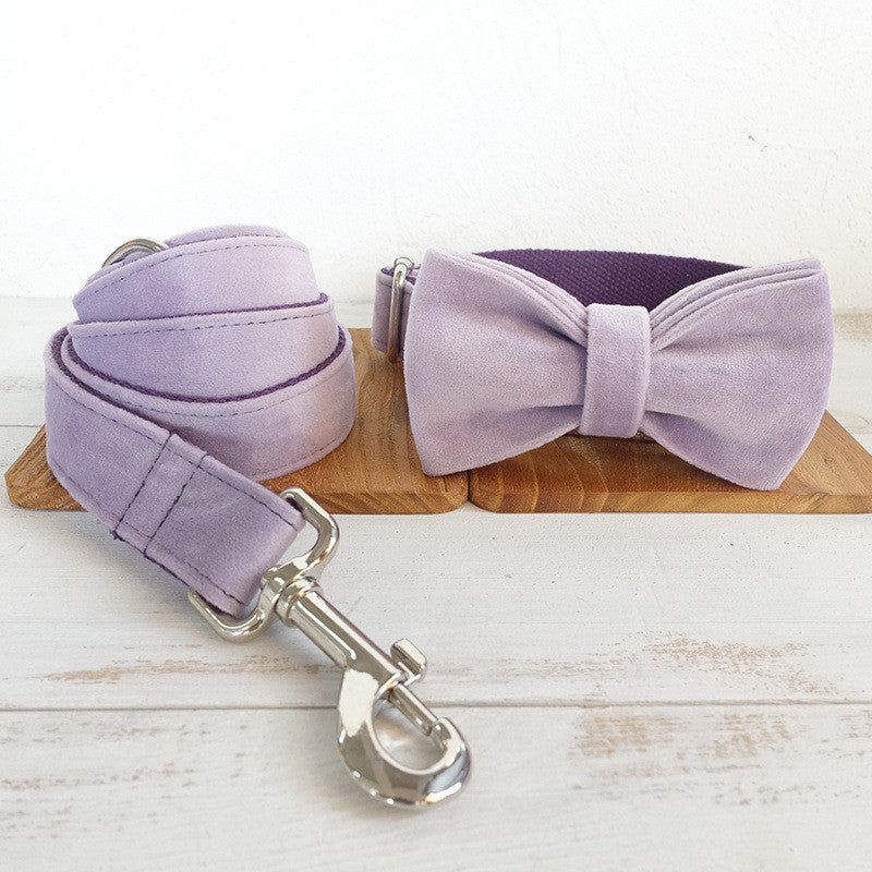 Light purple velvet dog collar with bow tie and matching leash on wooden board