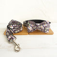 Load image into Gallery viewer, Floral patterned dog collar with attached bow tie and matching leash laid flat on wooden boards

