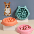 Load image into Gallery viewer, Three interactive slow feeder pet bowls in green, orange, and pink with bone-shaped ridges, dog figure in background
