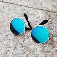Load image into Gallery viewer, Metallic gold-framed round sunglasses with blue mirrored lenses on stone surface
