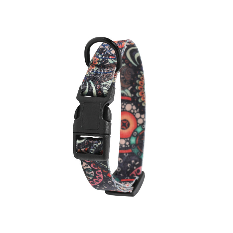 Close-up of plastic buckle and D-ring on black and paisley design dog collar
