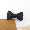 Load image into Gallery viewer, Close-up of black satin pet bow tie resting on wooden board
