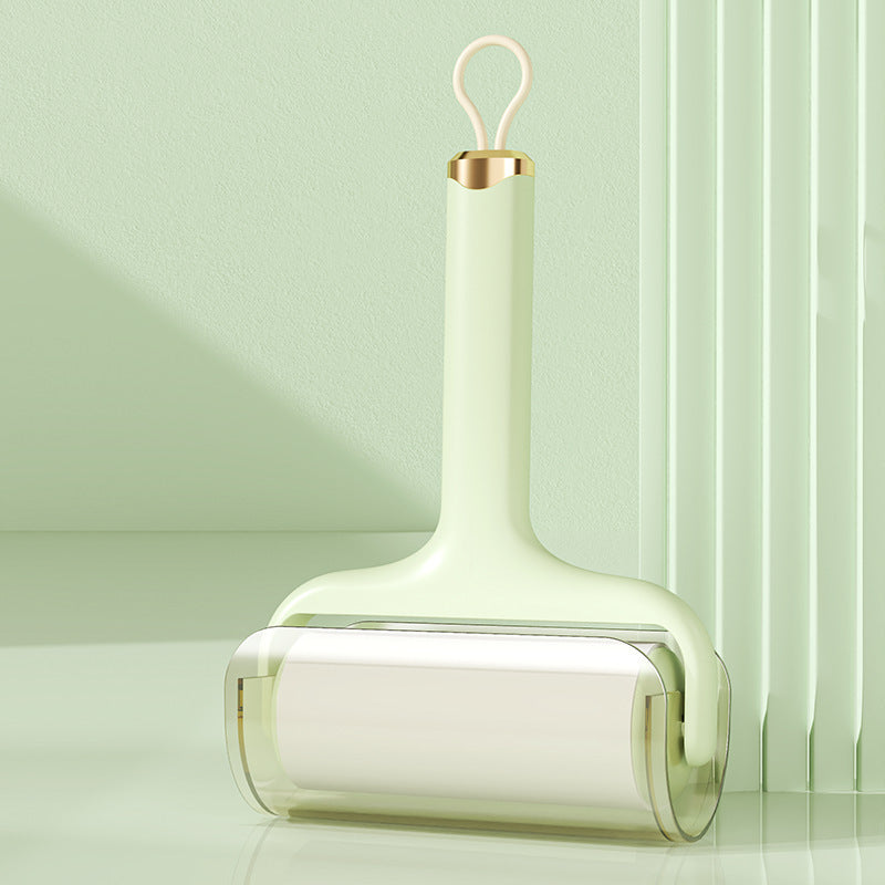 Pastel green handle sticky hair roller with transparent cover against green background