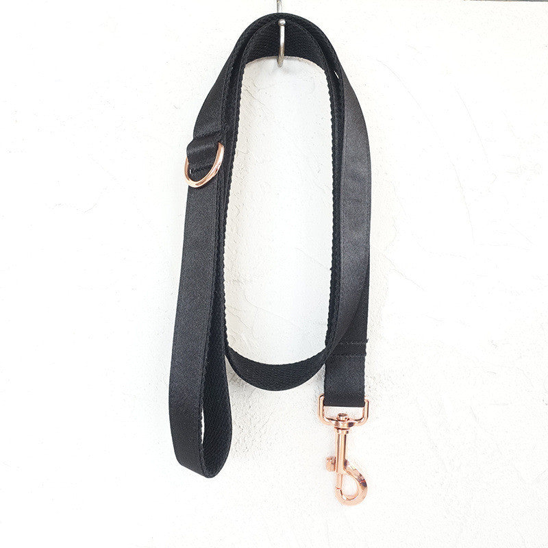 Full view of black satin pet leash hanging with rose gold hardware