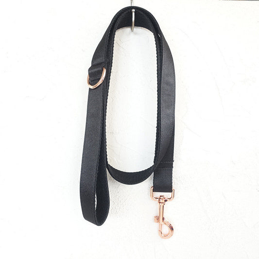 Full view of black satin pet leash hanging with rose gold hardware