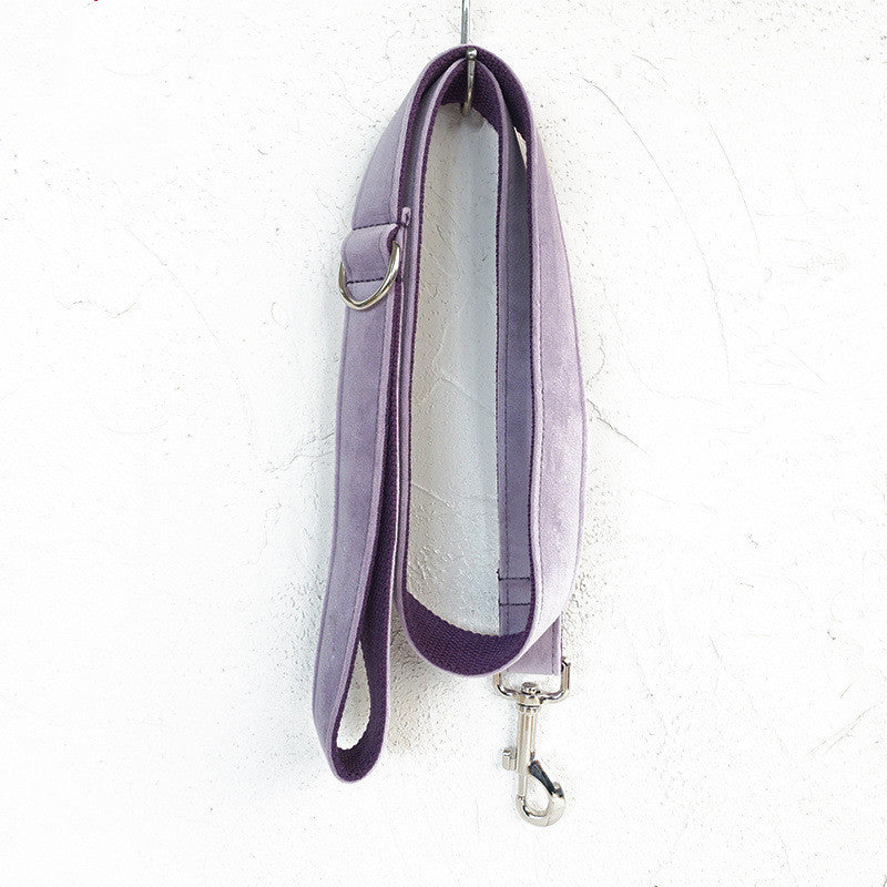 Light purple velvet leash hanging neatly against white textured wall