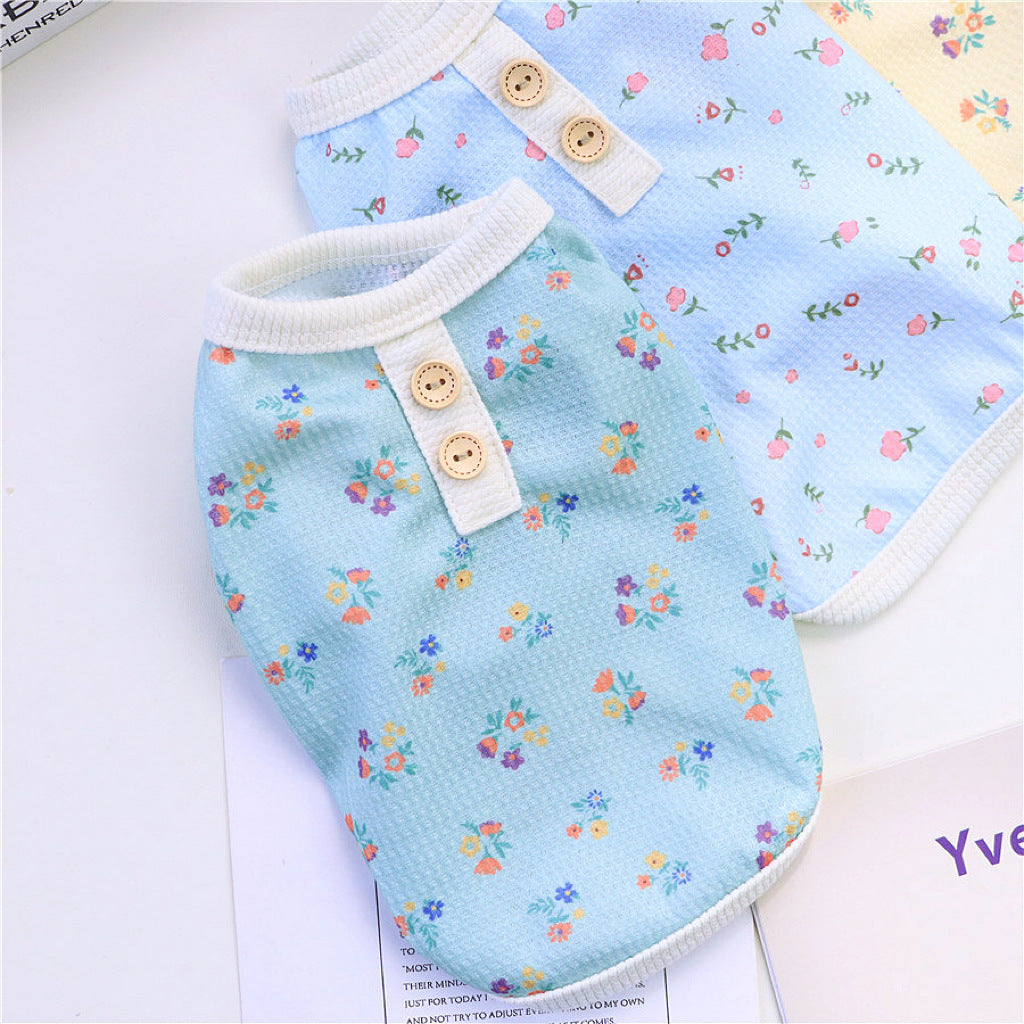 Two floral dog pajamas in blue and yellow colors laid next to each other
