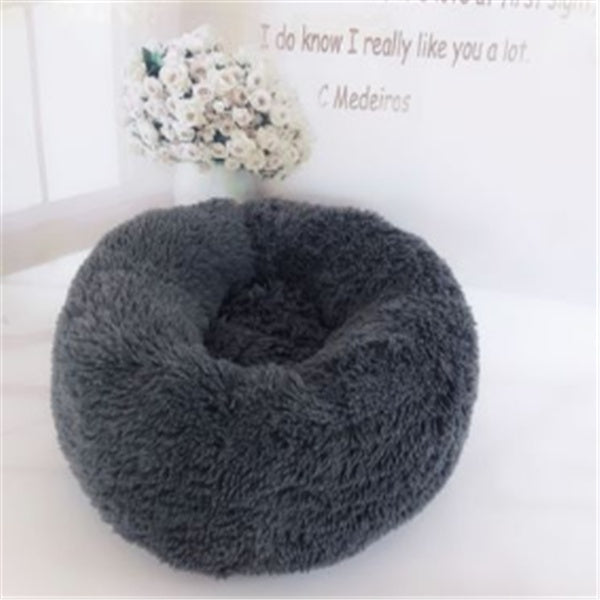 Dark gray round plush pet bed shown in a clean indoor setting