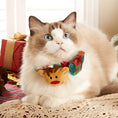 Load image into Gallery viewer, Fluffy white and brown cat wearing a plush Christmas collar with a cute reindeer and gift decoration, sitting on a crocheted cloth
