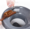 Load image into Gallery viewer, Close-up of hand placing treats into feeder's top compartment with a plastic scoop
