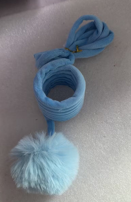 Roll of blue velvet spring material and attached fluffy ball