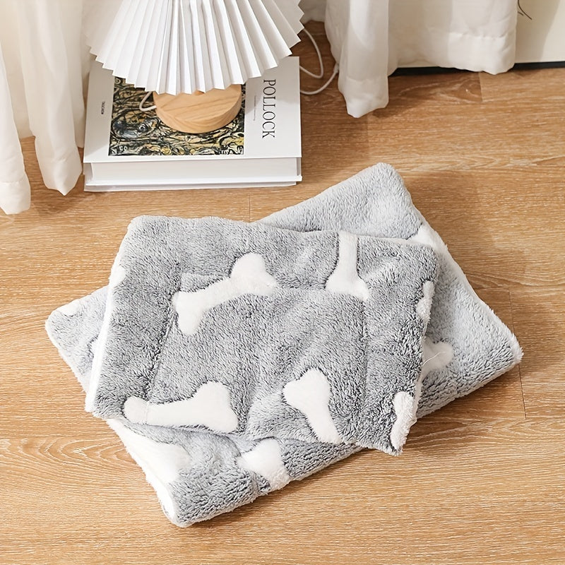 Stacked pet bed mats folded neatly on wooden floor with gray and white bone pattern