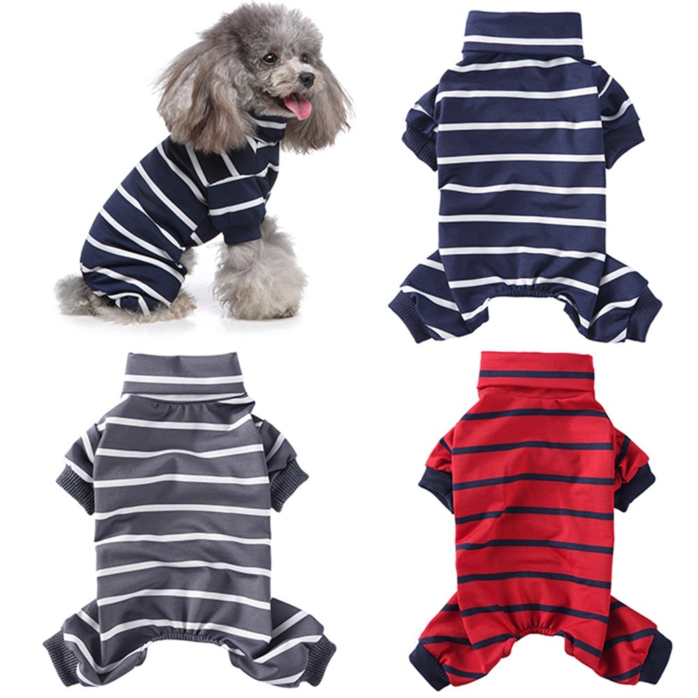 Small gray poodle wearing navy blue and white striped high collar dog pajamas sitting and panting