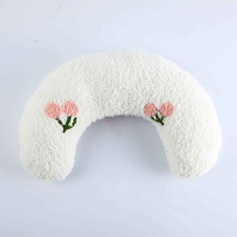 White U-shaped plush pet pillow with pink flower embroidery on white background