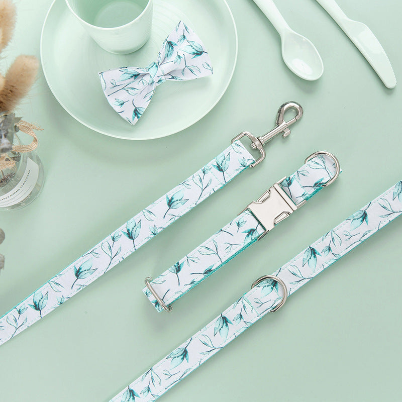 Flat lay of coordinating leash and collar with bow tie alongside white dish and cutlery