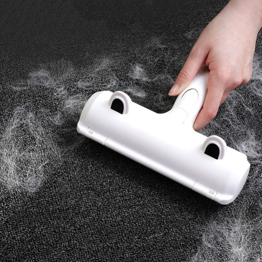 Hand using white pet hair remover roller cleaning pet hair from dark carpet