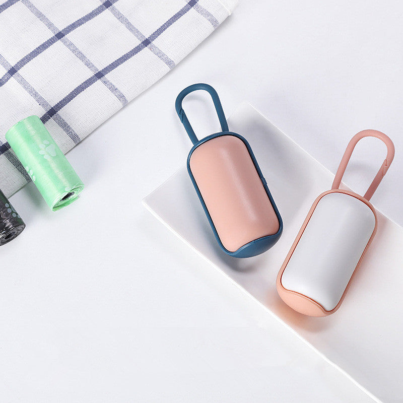 Top view of blue-pink and white-pink portable poop bag dispensers with pet waste bag rolls nearby