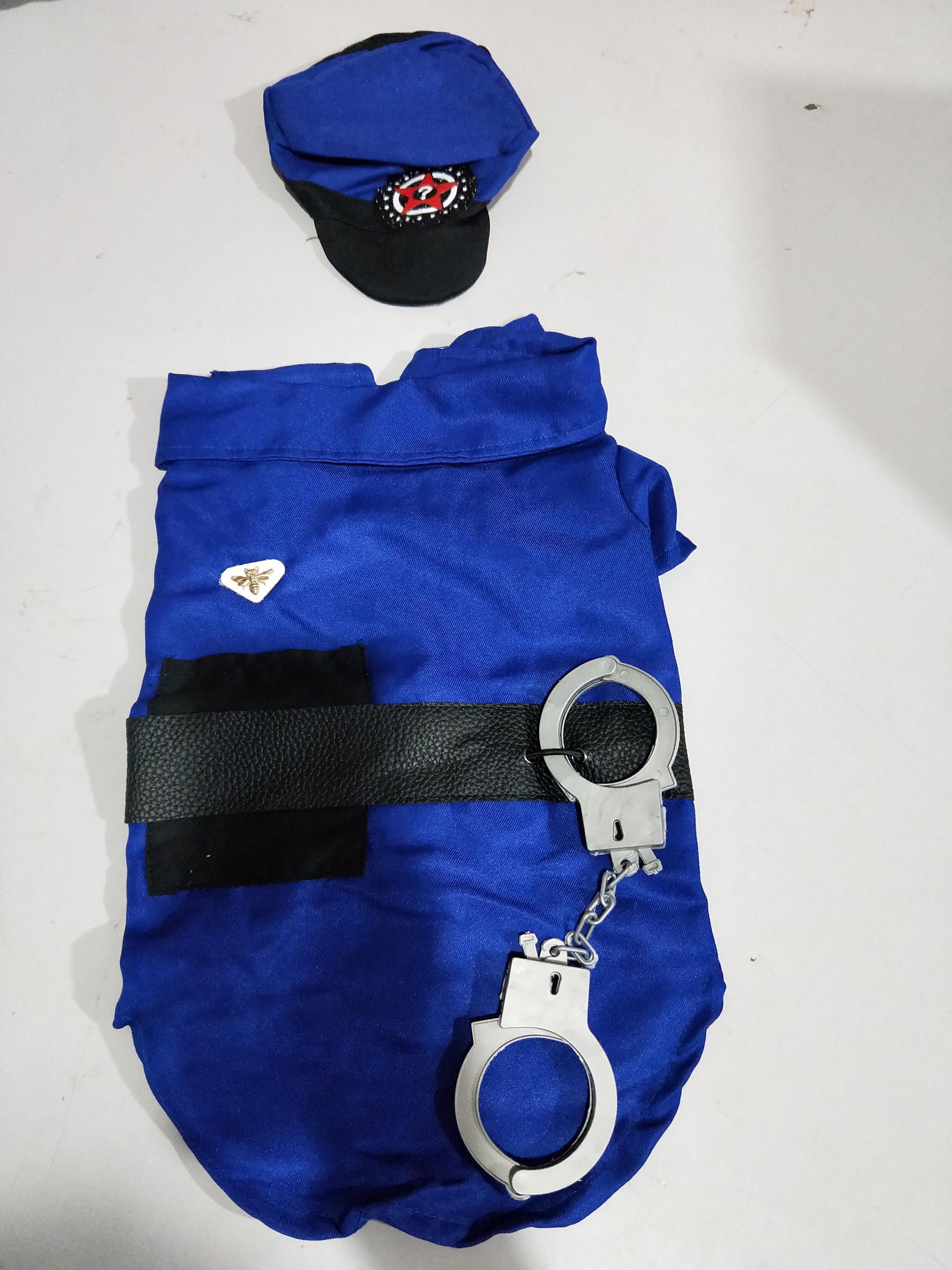 Close up flat lay image of royal blue police dog costume with black belt and toy handcuffs and police hat on white surface