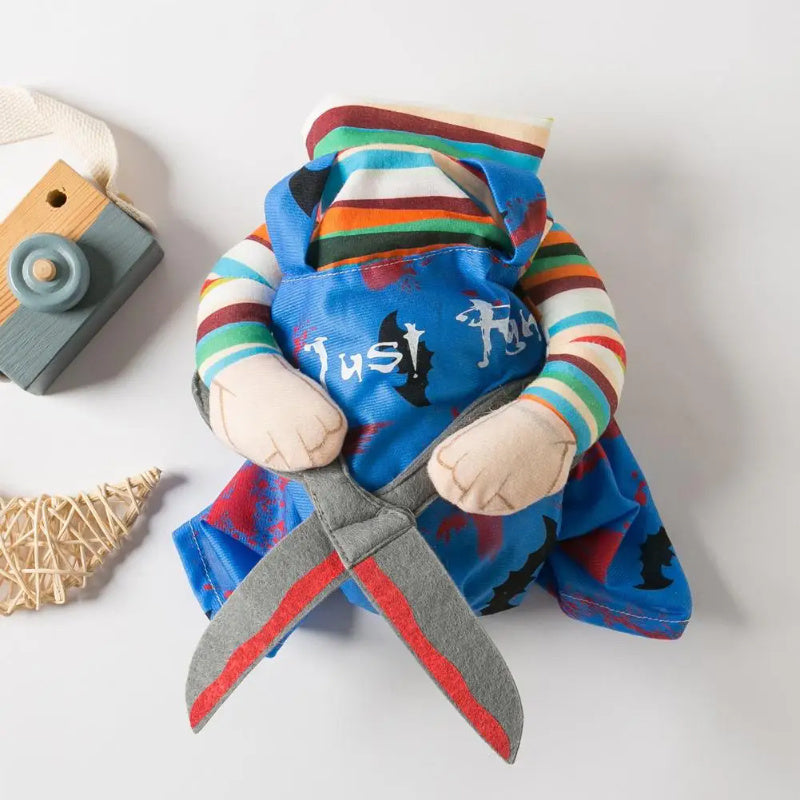 Close up of blue scissor hands pet Halloween costume with striped sleeves and plush arms holding crossed scissors