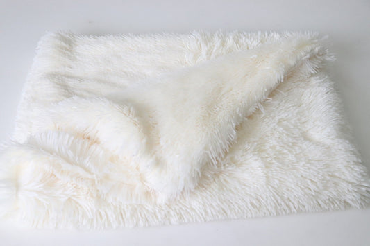 Ivory plush pet blanket folded on a white surface showing soft faux fur texture