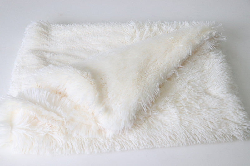 Ivory plush pet blanket folded on a white surface showing soft faux fur texture