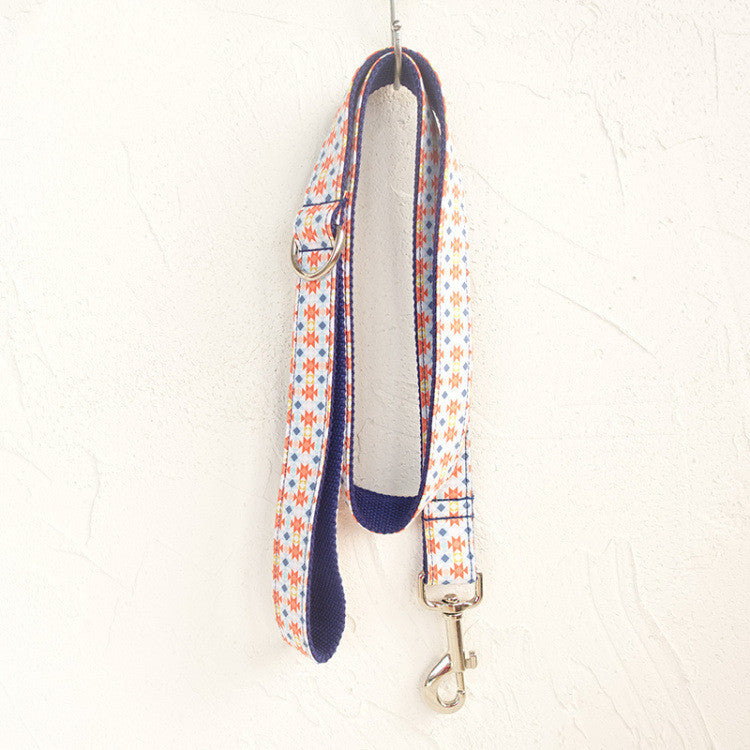 Full view of patterned polyester dog leash hanging with metal clasp and D-ring