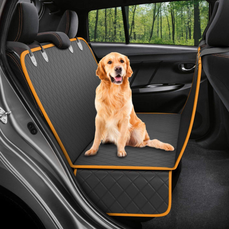 Golden retriever sitting on black quilted waterproof car seat cover with orange trim installed in rear car seat