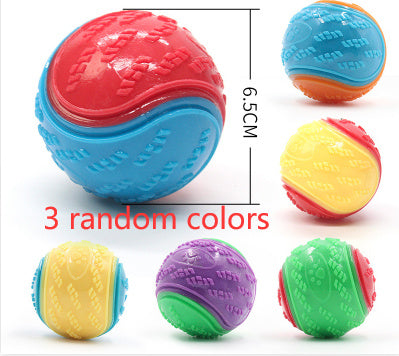 Close-up of red and blue rubber dog chew ball with measurement showing 6.5 cm diameter and a group of other colored balls