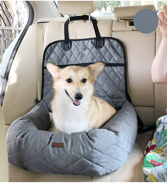Gray quilted dog car seat bed installed in a car rear seat with a happy small dog sitting inside, displaying real-life use case