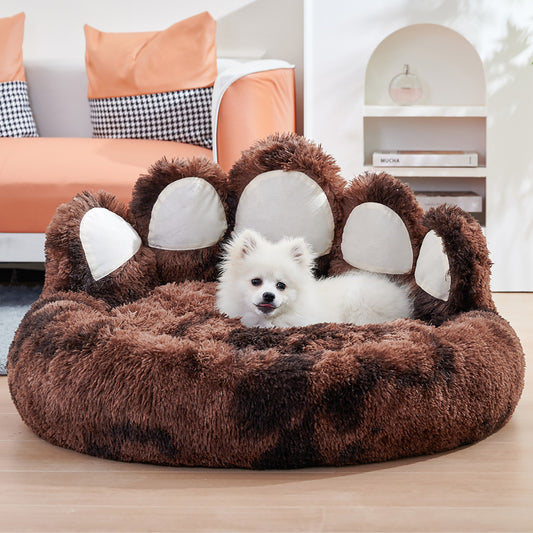 Brown bear paw plush dog bed with white dog lying comfortably in living area