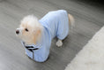Load image into Gallery viewer, Small white dog standing on floor wearing light blue microfiber drying robe looking sideways
